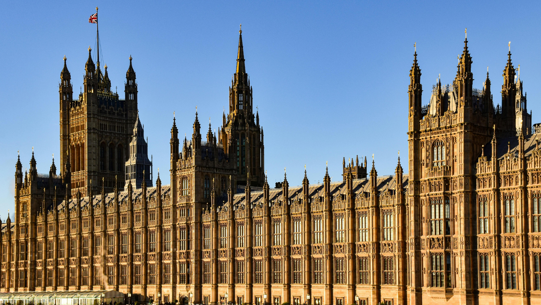A view of the UK Houses of Parliament on a sunny day.